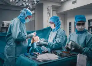 Surgeons and nurses performing a ACL replacement knee surgery on patient in operation room