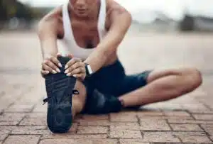 Woman stretching prior to completing fitness exercise to prevent injury.