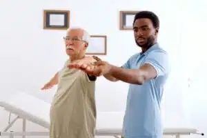 a physical therapist assisting a senior man