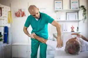 Physical therapist working on rshoulder pain ecovery of his patient in doctor's office